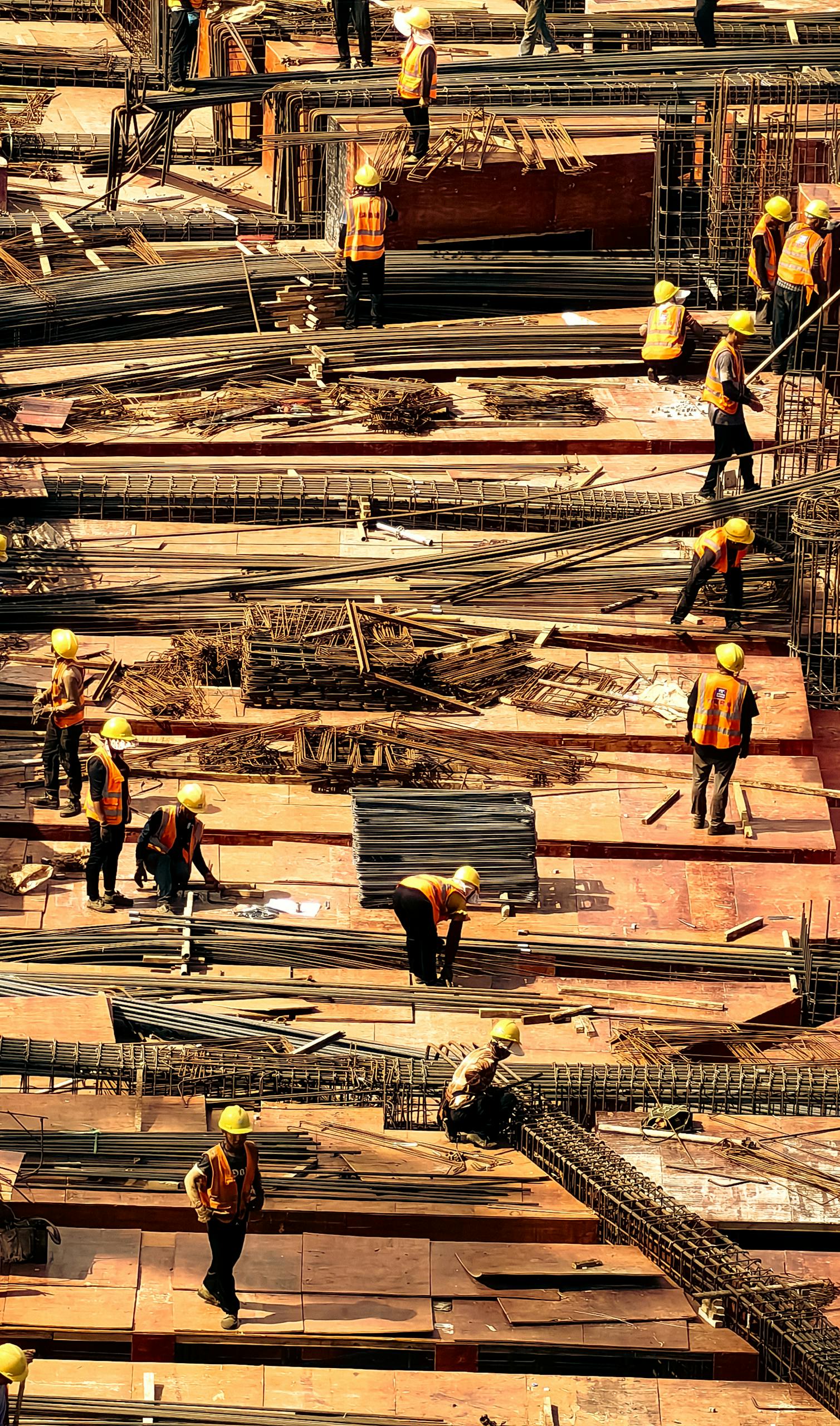 Workers in safety gear actively working on a large construction site.